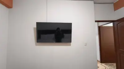a television on a white wall in a room at Departamentos Sumaq Plaza - Libertad in Ayacucho