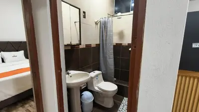 a small bathroom with a toilet and a sink at Departamentos Sumaq Plaza - Libertad in Ayacucho