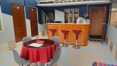 a table and chairs in a room with a bar at Cozy Mini-Apartment-Cusco in Cusco