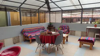 a room with a table and chairs and windows at Cozy Mini-Apartment-Cusco in Cusco