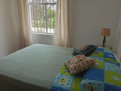 a bedroom with a bed with a quilt and a window at KUSIHaus in Lima