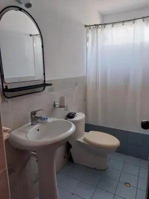 a bathroom with a sink and a toilet and a mirror at KUSIHaus in Lima