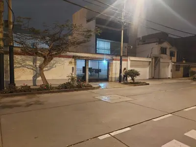 an empty parking lot in front of a building at night at KUSIHaus in Lima