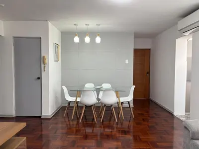 a dining room with a glass table and white chairs at 2Br Apartment Miraflores in Lima