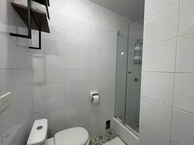 a white bathroom with a toilet and a shower at 2Br Apartment Miraflores in Lima