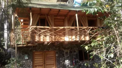 a wooden building with a balcony on top of it at Glamping Machupicchu Lodge in Santa Teresa