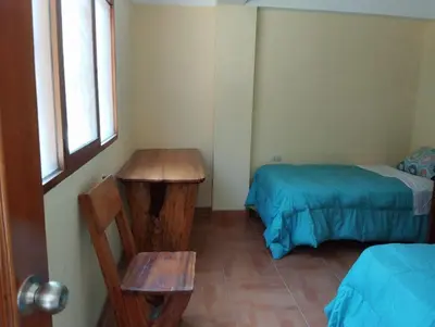 a room with two beds and a table and a window at Glamping Machupicchu Lodge in Santa Teresa