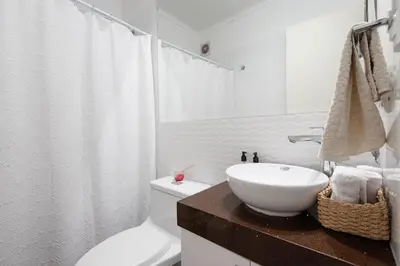 a white bathroom with a sink and a toilet at Duplex in the best area of Barranco in Lima