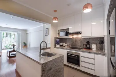 a kitchen with white cabinets and a granite counter top at Duplex in the best area of Barranco in Lima