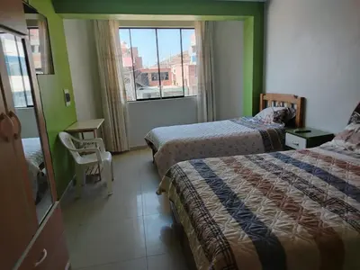 a hotel room with two beds and a window at Hospedaje el Mirador del Pillcomozo in Huánuco