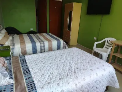 a bedroom with a bed and a table and a chair at Hospedaje el Mirador del Pillcomozo in Huánuco