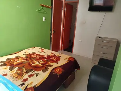 a bedroom with a bed and a dresser at Hospedaje el Mirador del Pillcomozo in Huánuco