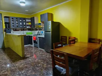 a kitchen with a wooden table and a refrigerator at Hospedaje el Mirador del Pillcomozo in Huánuco