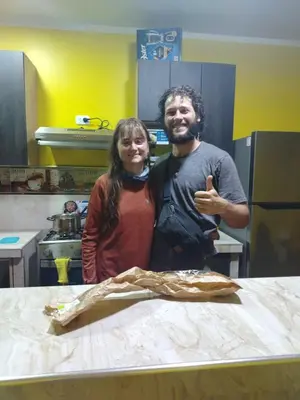 a man and woman standing next to a table in a kitchen at Hospedaje el Mirador del Pillcomozo in Huánuco