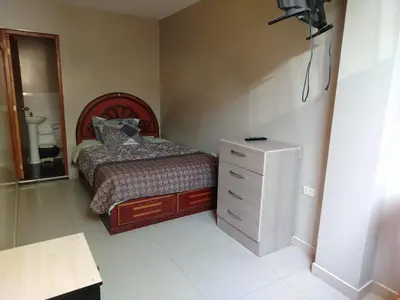 a small bedroom with a bed and a dresser at Hospedaje el Mirador del Pillcomozo in Huánuco