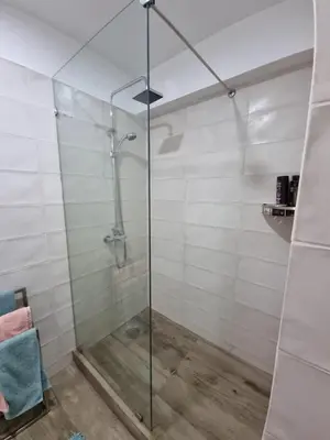 a shower with a glass door in a bathroom at Inka Home VIP Luxury total 2 Private parking spaces in Lima