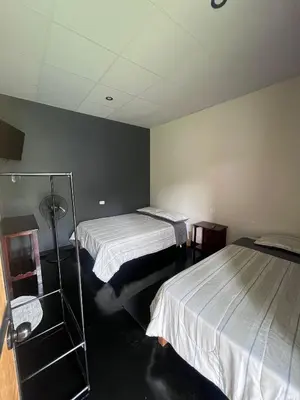a hotel room with two beds and a mirror at La Posada de Chango in La Merced
