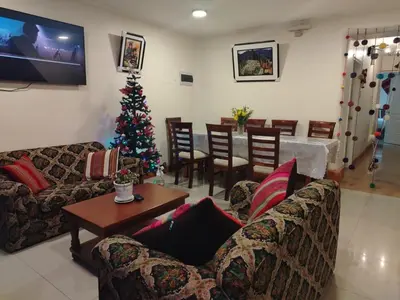 a living room with a christmas tree and a table at Imperium House Cusco in Cusco