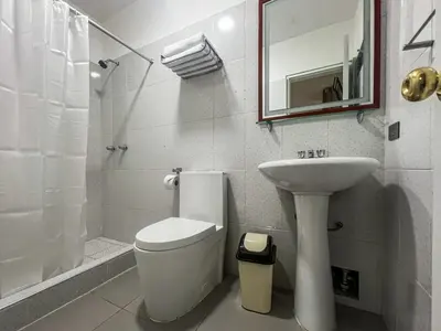 a white bathroom with a toilet and a sink at Imperium House Cusco in Cusco