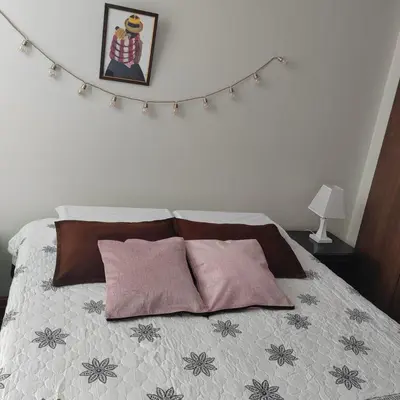 a bedroom with a bed with pink pillows at Elite Apartment in Cusco