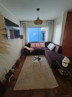 a living room with a purple couch and a table at Elite Apartment in Cusco