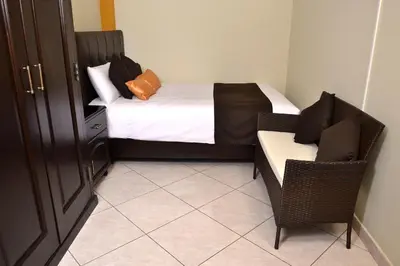 a small room with a bed and a couch and a chair at Hostel Esperanza in Lima