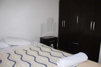 a bedroom with a bed and a black cabinet at Cozy apartment in San Miguel in Lima
