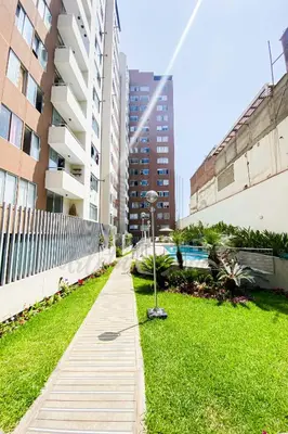 a walking path in a city with tall buildings at Cozy apartment in San Miguel in Lima