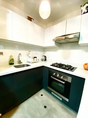 a kitchen with white cabinets and a black stove top oven at Exclusive apartment in Miraflores in Lima