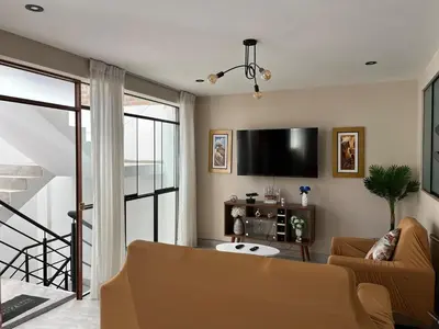 a living room with a couch and a flat screen tv at Departamento de Estreno Amplio y Confortable in Ayacucho