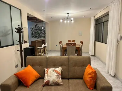 a living room with a couch and a dining room at Departamento de Estreno Amplio y Confortable in Ayacucho
