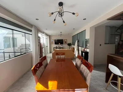 a dining room and living room with a wooden table at Departamento de Estreno Amplio y Confortable in Ayacucho