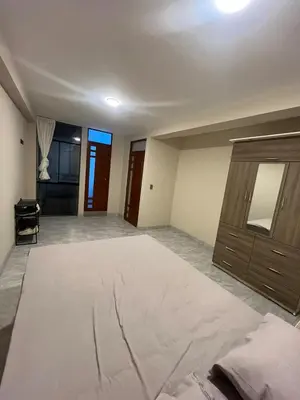 an empty room with a large bed and a dresser at Departamento de Estreno Amplio y Confortable in Ayacucho