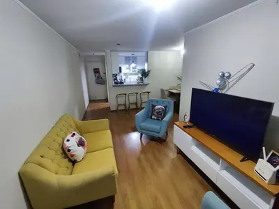 a living room with a yellow couch and a television at Acogedor departamento con cochera in Lima