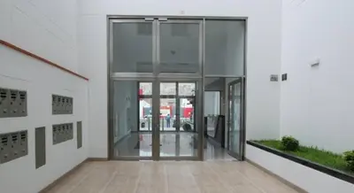 an empty hallway of a building with glass doors at Acogedor departamento con cochera in Lima