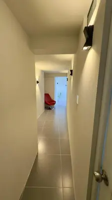 a hallway with a red chair in a room at Habitación Matrimonial en el centro de la ciudad in Ayacucho