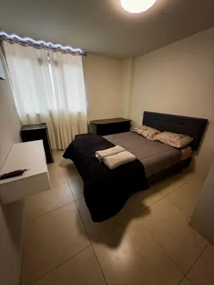 a bedroom with a bed and a desk and a table at Habitación Matrimonial en el centro de la ciudad in Ayacucho
