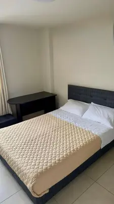 a large bed in a bedroom with a desk at Habitación Matrimonial en el centro de la ciudad in Ayacucho