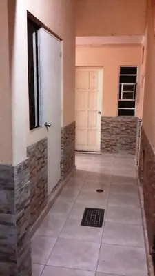 a hallway with a door and a tile floor at Hotel Pradera Verde Inn in Lima