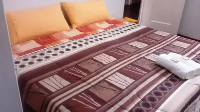 a bed with a comforter and a phone on it at Hotel Pradera Verde Inn in Lima