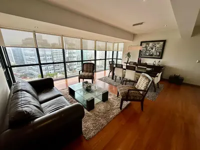 a living room with a leather couch and a table at Increible vísta al Malecón de Miraflores in Lima