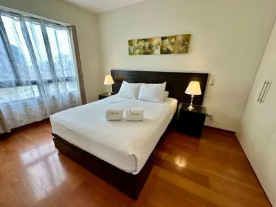 a bedroom with a large white bed with two lamps at Increible vísta al Malecón de Miraflores in Lima