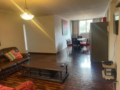 a living room with a couch and a table at Miraflores Dpto 3 dormitorios in Lima