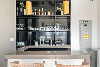 a kitchen with a bar with a counter and chairs at Edificio The Classic in Lima