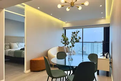 a dining room with a table and chairs and a bedroom at Torre Gold in Lima