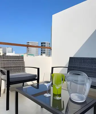 a table with two glasses and a glass bowl on a balcony at Iconic Miraflores Penthouse 3BR in Lima