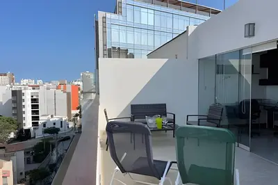 a balcony with two chairs and a table on a building at Iconic Miraflores Penthouse 3BR in Lima