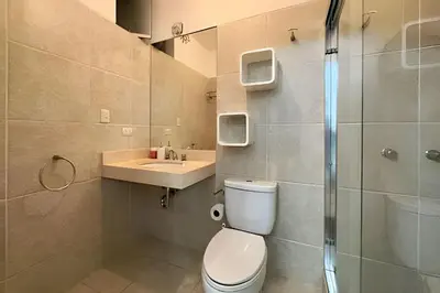 a bathroom with a toilet and a sink and a shower at Iconic Miraflores Penthouse 3BR in Lima