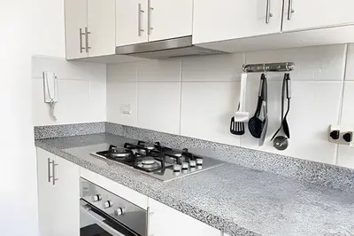 a white kitchen with a stove and white cabinets at Iconic Miraflores Penthouse 3BR in Lima