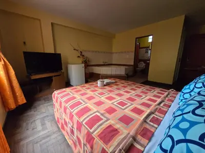 a bedroom with a large bed and a flat screen tv at Sahara Hotel in Lima